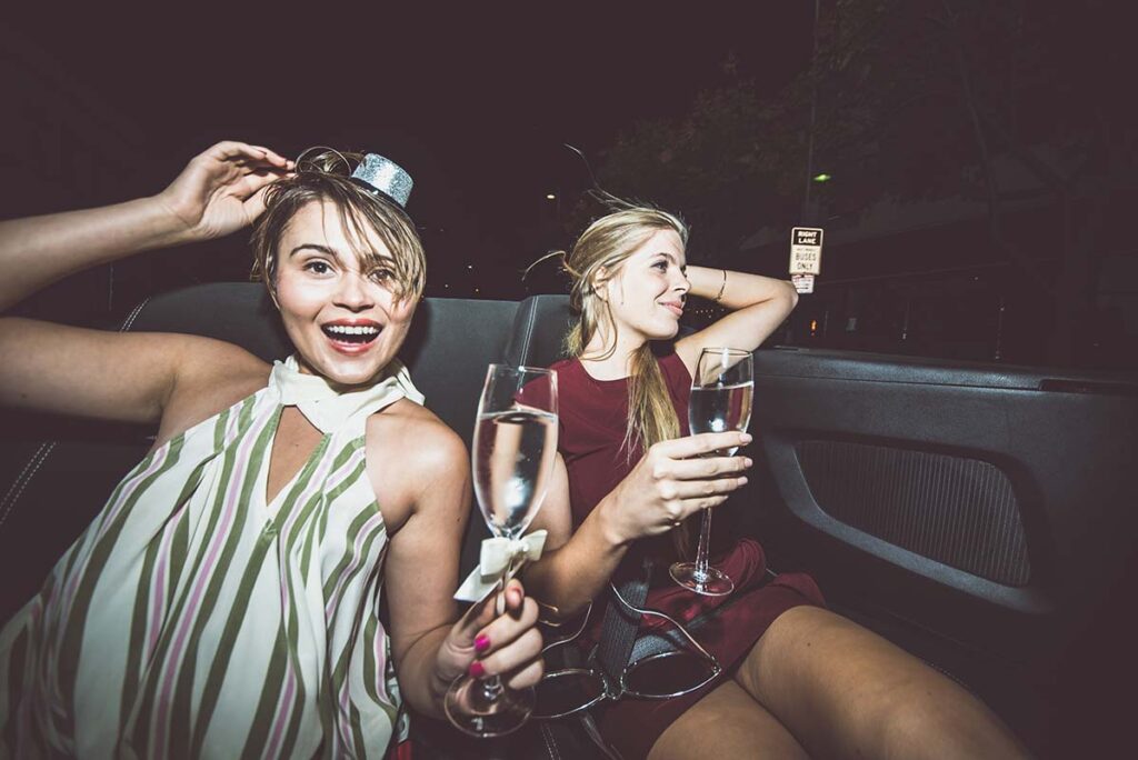 girls celebrating birthday drinking in luxury limousine