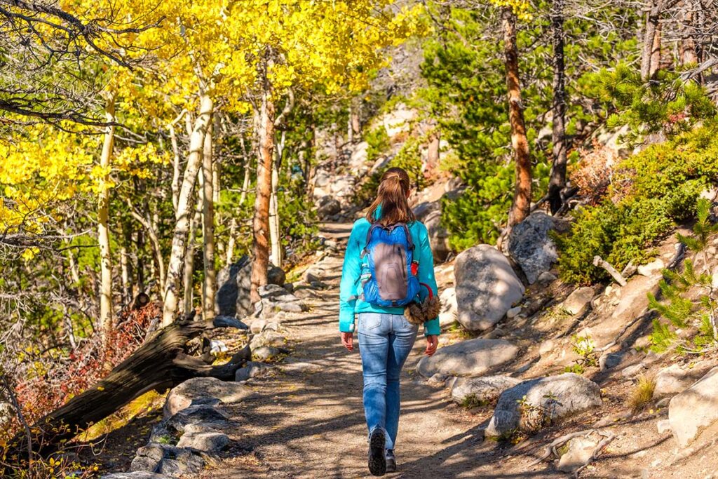 Woman tourist walking on trail in Vail Mountain in the summer
