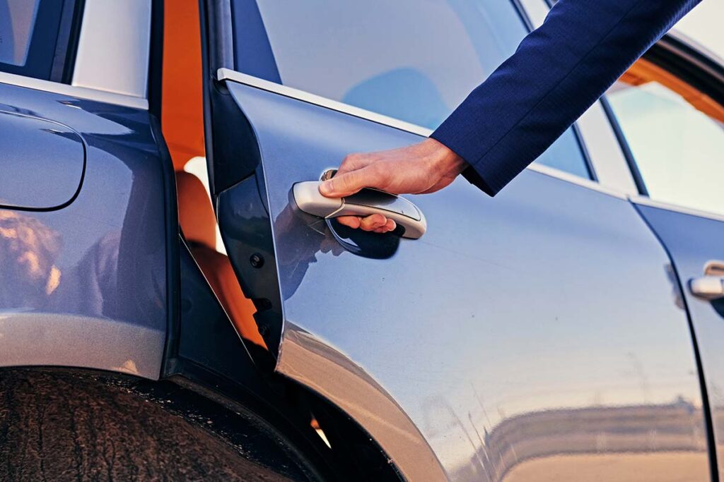 Close up image of a man opens a limo car door