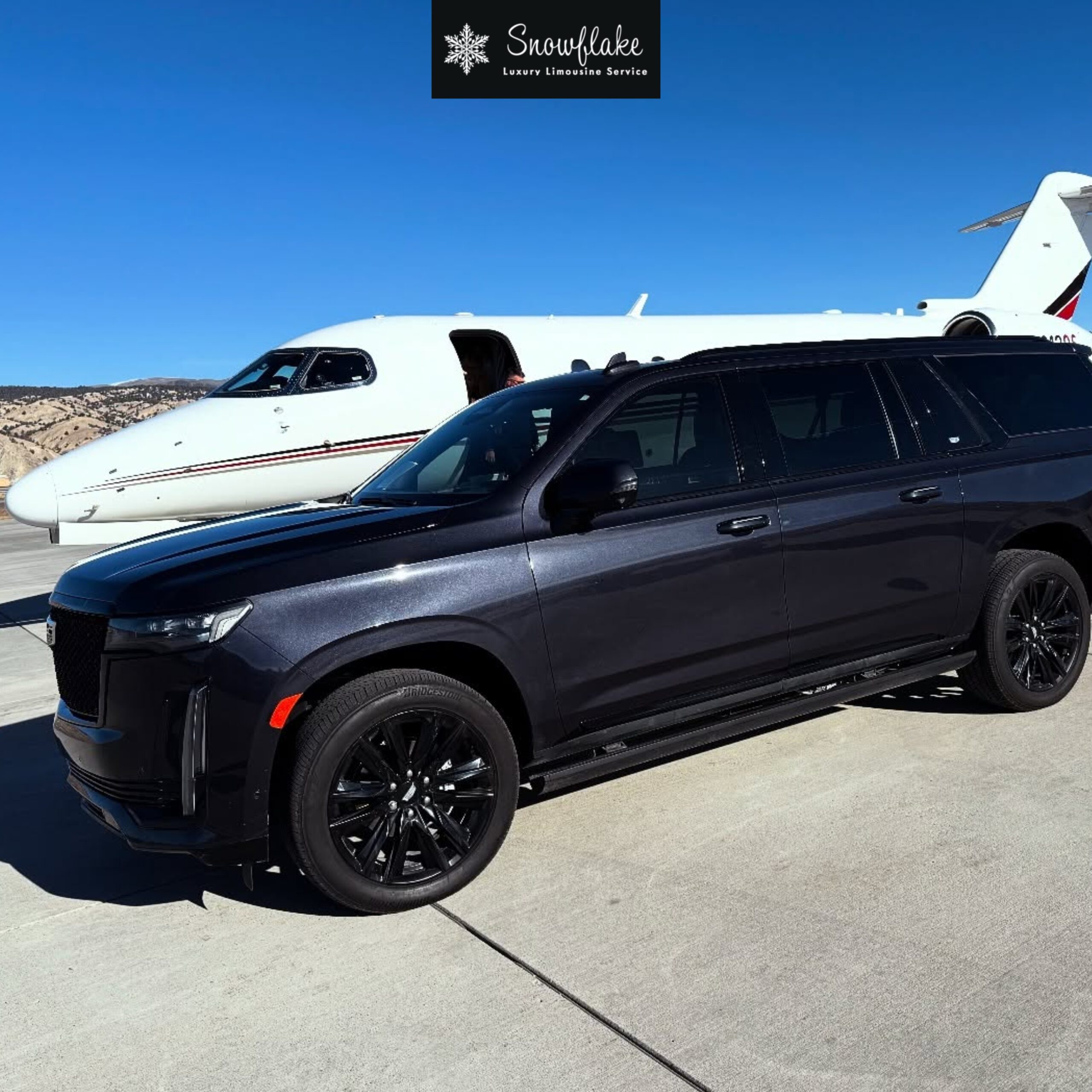Black Cadillac SUV parked beside a private jet at an airport