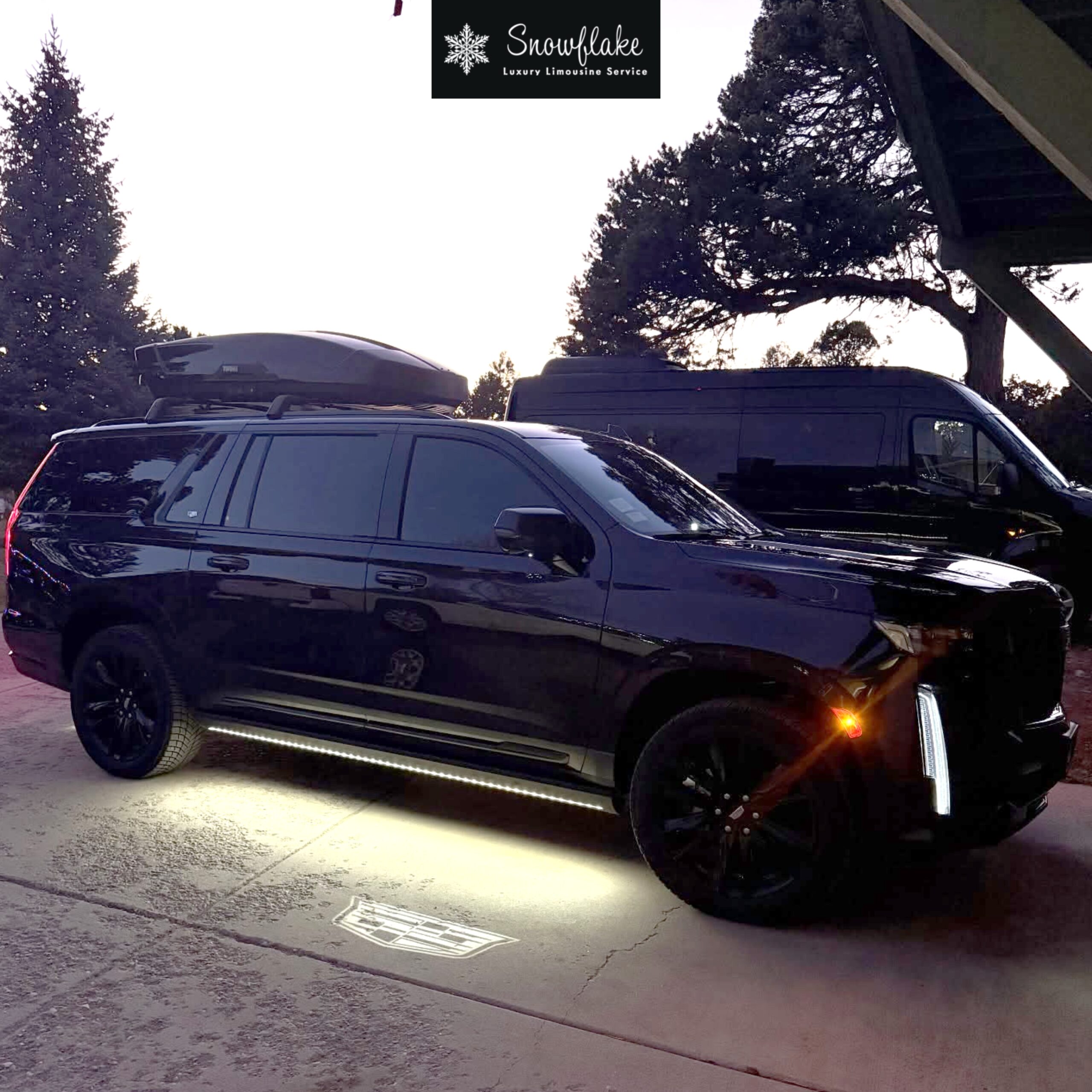 Luxury black SUV parked outside a lodge for Snowflake Limousine Service.