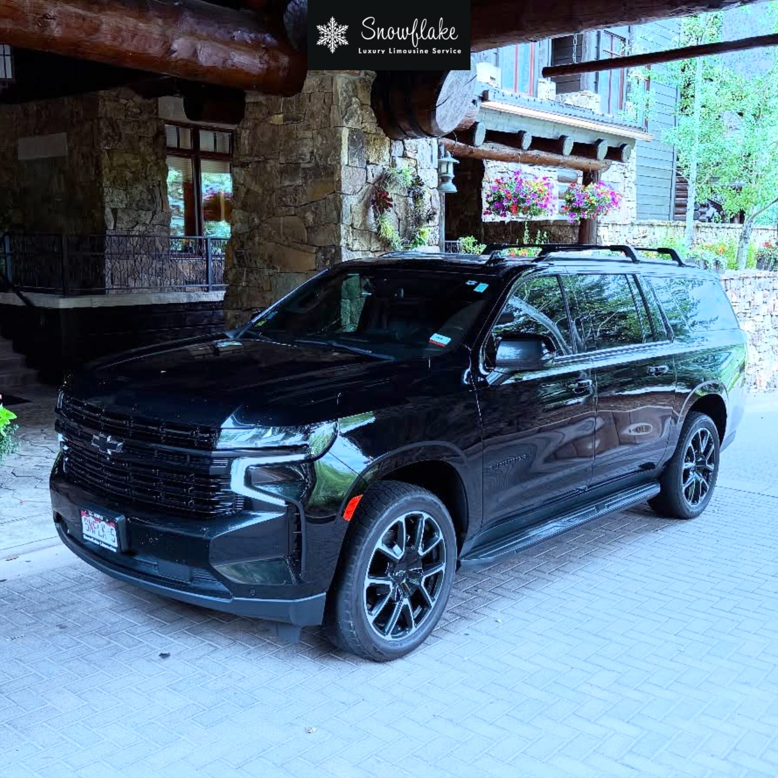 Black luxury SUV parked at a mountain lodge for Snowflake Limousine Service.